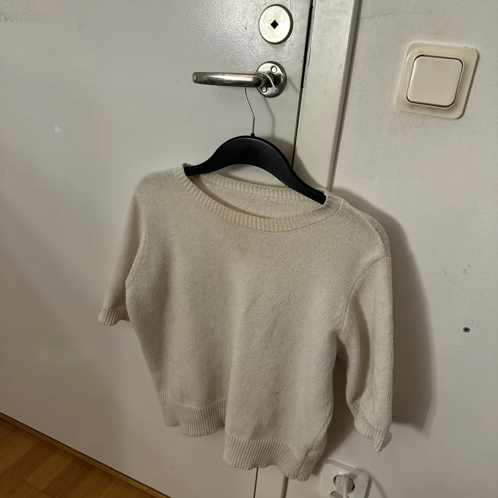 Stickad trekvartsärmad tröja som är köpt på en butik i Spanien, tröjan har en smink fläck vid halsen som man ser på bild två men det är inget som syns när man har på sig den . T-paidat.