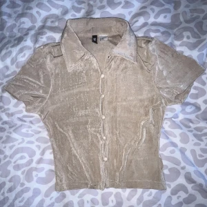 Tshirt ”skjorta” - Fin tröja från h&m, alla knappar går att stänga/öppna så går att välja själv hur mkt man vill visa 🤎 Färgen är nån mix av Khaki/Beige/Brun, svårt att få rättvis färg på bilderna 😭