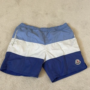 Moncler bad shorts  - ACCEPTERAR BYTEN! Äkta moncler bad shorts i storlek XS i nyskick, säljer för jag inte passar i den, inte använd. Köpt för flera månader sen. Pris kan diskuteras. KOM MED BUD