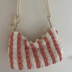 Väska - Supersöt sommarväska som är orange och vit.  Har dessvärre en liten fläck på sig som säkert går bort men har inte testat. Annars felfri! 