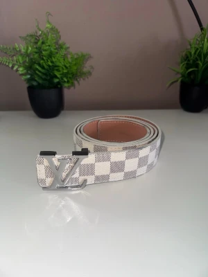 Rutigt bälte - Snyggt rutigt bälte med en glansig logga där fram, perfekt för dig som gillar en clean street look!