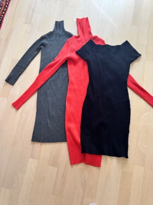Ribbstickade långklänningar Zara Knit - Tre ribbstickade långklänningar från Zara Knit i färgerna svart, röd och grå. Klänningarna har lång ärm och är figurnära med en enkel, stilren design. Perfekta för dig som gillar en clean och bekväm look.