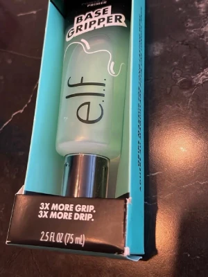e.l.f. Base Gripper Primer 75 ml - e.l.f. Base Gripper Primer i en genomskinlig tub med silverfärgat lock. Primern har en lätt grön ton och kommer i en förpackning på 75 ml. Perfekt för att få sminket att sitta längre och ge extra fäste till din bas.