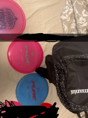 Discgolfsset med väska och tre diskar - Säljer ett discgolfsset med tre diskar: en rosa Warship, en rosa Fuse och en blå Pure. Medföljer gör en svart väska från discmania med vita detaljer och flera fack. Perfekt för dig som vill börja eller utveckla ditt discgolfspel. Tar bara Instabox beställningar
