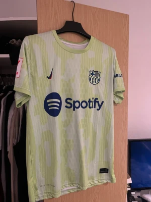Barcelona Lamine Yamal tröja 24/25 M - Säljer en ljusgrön Barcelona fotbollströja med Lamine Yamal på ryggen.