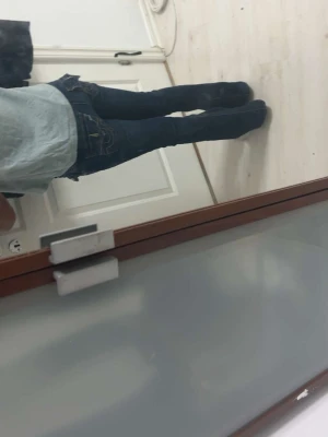 Mörkblå bootcut jeans med fickdetaljer - Säljer ett par mörkblå bootcut jeans med snygga kontrastsömmar och dekorativa fickor bak med lock och knappar. Jeansen har låg midja och utsvängda ben, perfekt för en trendig och avslappnad look.