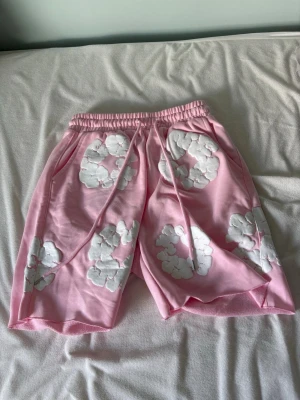 Rosa shorts med vita blommor - Säljer mina helt nya denim tears shorts då jag råka köpa en storlek för liten                                              Skriv vid frågor!