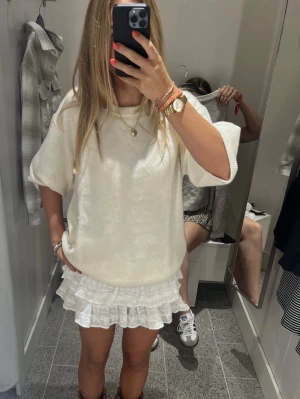 Vit volangkjol  - Supersöt vit kortkjol från H&M Divided med flera lager volanger. Kjolen är i bomull och har en lätt och luftig känsla, perfekt för varmare dagar. Enkel att matcha med både t-shirt och stickad tröja.