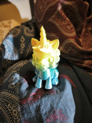 Färgglad enhörningsfigur i plast - Säljer en liten enhörningsfigur i plast med gul och blå färgskiftning. Figurer har stora ögon, spiralformat horn och detaljerad man. Perfekt som dekoration eller leksak för den som gillar magiska varelser.