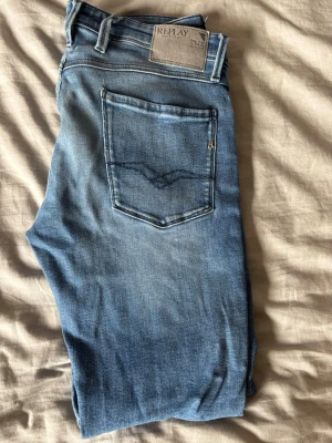Blå jeans från Replay, modell Anbass - Snygga blå jeans från Replay i modellen Anbass. Jeansen har klassisk femficksdesign, ljus tvätt 