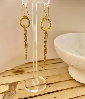 Guldiga statementörhängen i rostfritt stål med ringar - Unika örhängen i guldfärgad stål med stora cirkelformade ringar och hängande kedjor med små dekorativa detaljer. Snyggt boho-inspirerat uttryck som drar blickarna till sig. Perfekta för dig som gillar att sticka ut med accessoarer.