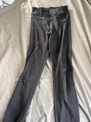 Svarta höga leggings - Säljer ett par svarta leggings med hög midja och smal passform. De är stretchiga och mjuka, perfekta för en avslappnad look. Materialet känns lent och följsamt mot huden. Passar till det mesta och är superenkla att styla.