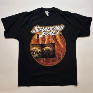 Shadows Fall Of One Blood T-shirt - Band-tee från bandet Shadows Fall med tema från deras år-2000 album ”Of One Blood”.  Nyskick. Necktags är knyckliga för tröjan legat ihopvikt i ett tag. Rätar ut sig vid tvätt.  100% bomull  Skicka ett meddelande om du har frågor eller vill se fler bilder