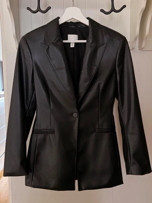Svart blazer - Snygg svart blazer från H&M, inte riktigt läder. Stretchigt och mjukt material. Aldrig använd. Skriv till mig vid frågor 🖤