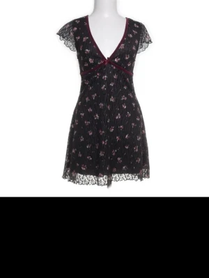 Svart spetsnattlinne med blommor - Sött miniklänning från Urban i spets med små rosa och lila blommor. Kan bäras på klubb eller till vardags med tajts eller shorts under, eller utan shorts om man vill.