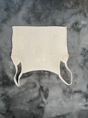 Ribbad beige croppad linnetopp - Säljer en ribbad beige croppad linnetopp från LOUNGE i storlek XS. Toppen har smala axelband och broderad logga framtill. Perfekt för dig som gillar en enkel men trendig stil.