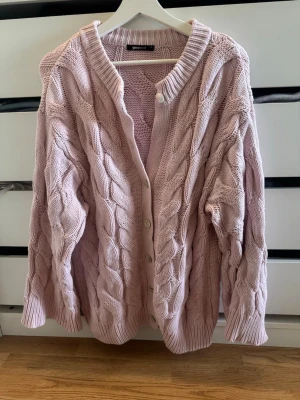 Rosa kabelstickad kofta Gina Tricot  - Rosa kabelstickad kofta ifrån Gina Tricot i storlek M🤍 en av knapparna saknas, se bild 