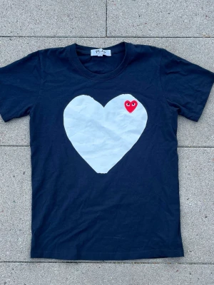 Comme des garçon T-shirt - Säljer den här cdg tishan i storlek M, säljer pga av att den är för liten, den är i 9/10 skick! Bara stora hjärtat som är lite creased, vilket man kan säkert fixa, hör av er vid minsta fråga!⚠️oklart om den är äkta⚠️