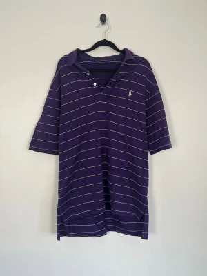 Polo Golf Ralph Lauren Pikétröja Lila Randig Pima Cotton Regular Fit Stl M - • Storlek: M • Färg: Lila med vita ränder • Passform: Regular Fit  • Krage: 3-knappsstängning • Material: 100% Pima Cotton   Skick: Plagget är i väldigt fint skick. Eventuella anmärkningar anges alltid tydligt i beskrivningen och visas på bilderna.  Nypris: Cirka 1 500 kr.  📦 Skickas snabbt och packas omsorgsfullt. 💬 Hör gärna av dig om du har frågor eller vill se fler bilder. 🤝 Samfrakt erbjuds vid köp av flera plagg – kika gärna in mina andra annonser!