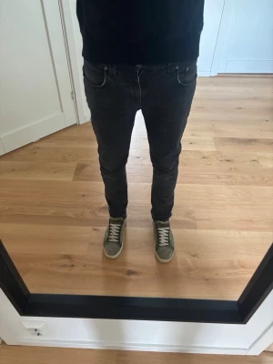 Mörkgråa nudie jeans - Mörkgråa jeans från nudie I modellen Thin Finn, 32/32 (188,80kg på bilden) litet hål i skrevet men går att laga gratis i nudies affärer! Hör av er vid frågor!