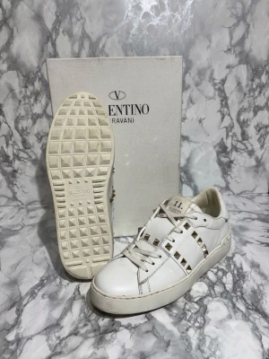 Valentino rockstuds - Säljer ett par valentino opens rockstuds   i mycket fint skick. Storlek: 37 fits 38 Skick: 9,6/10 Färg: vita med guldiga spikar 📦 Ingår: box + extra snöre + valentino kort💰 Pris: 2499 kr Snabb affär prioriteras – seriösa bud välkomna. Skriv gärna för fler bilder eller frågor.  