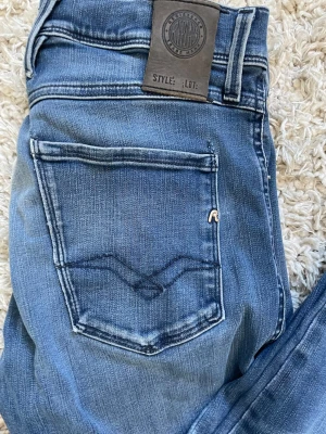 Blå slim fit jeans med bakficka - Säljer ett par blå feta replay anbass som har tyvärr blivit för små för mig. Jeansen har bara en defekt och det är på bild 4. Priset är ej hugget i sten.