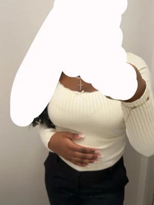 Vit ribbad långärmad topp - Snygg vit ribbad topp med lång ärm och rundad halsringning. Figurnära passform och stretchigt material som ger en bekväm känsla. Perfekt att matcha med både jeans och kjol för en trendig look.