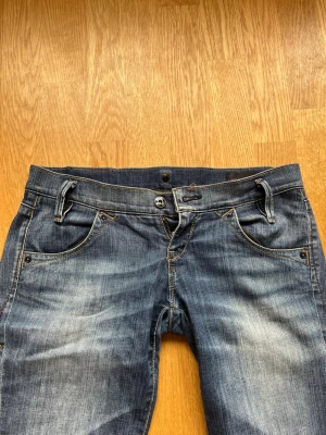Lågmidjade jeans  - Säljer ett par blå lågmidjade jeans från Lee i storlek S 