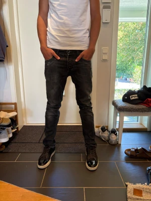 Svarta slim fit jeans herr Jack and Jones  - Säljer ett par svarta Jack and Jones slim fit jeans med klassisk femficksmodell och låg midja. Jeansen har en lätt tvättad look och smal passform som sitter snyggt längs benen. Perfekta till sneakers och t-shirt för en avslappnad stil. 31/34