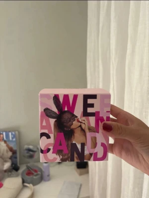 Sweet Like Candy parfym - Säljer en parfym i originalförpackning med rosa och lila design. Ariana Grande. Sidan har en autograf och ett läppstiftsavtryck. Perfekt för dig som gillar söta dofter.