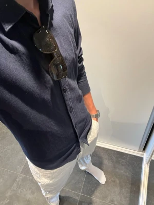 Hugo boss Skjorta - Snygg mörkblå skjorta med klassisk krage och knäppning framtill. Skjortan har lång ärm och är tillverkad i ett mjukt material som känns bekvämt mot huden. Perfekt för en clean och stilren look.