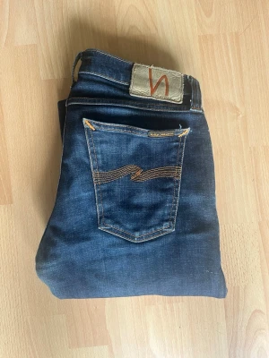 Mörkblå smala jeans med kontrastsömmar - Snygga mörkblå Nudie jeans i storlek w29 L32