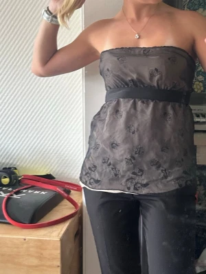 Intimissimi topp - Snygg svart axelbandslös tubtopp med subtila blommiga broderier och brett band under bysten. Från Intimissimi, fint skick!! Typ storlek S/M 🫶🏻🫶🏻