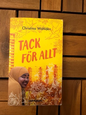 Tack för allt av Christina Wahldén - En ungdomsroman med gul och orange framsida, skriven av Christina Wahldén. Boken handlar om Hawa som drömmer om att bli polis och driver en egen detektivbyrå. Omslaget har illustrationer av blommor och stadsmiljö samt en leende tjej i hijab. Utgiven av Rabén & Sjögren. Köpt i juni läst 1 gång