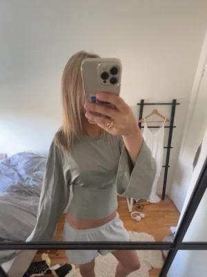Grön croppad topp med vida ärmar - Näst intill oanvänd!  Jag står inte för frakt, tar gärna emot bud under det satta priset för kompromiss!💗   Allt jag säljer är i stort sätt i nytt skick för ett lägre pris, kolla in resten av mina artiklar i min profil!