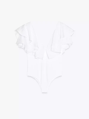 Vit body med volangärmar - Snygg vit body med djup V-ringning och stora volangärmar. Tillverkad i ett mjukt och stretchigt material som sitter skönt mot kroppen. Perfekt för dig som vill ha en trendig och feminin look med extra detaljer på axlarna.