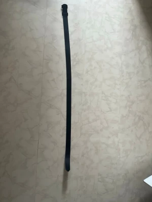 Svart klassiskt skärp i skinn - Snyggt och stilrent svart bälte i skinn med enkel design. Perfekt till jeans eller kostymbyxor för en clean look. Spännet är diskret och matchar bältets minimalistiska stil. 125cm 