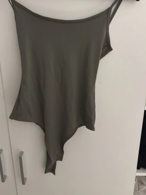 Olivgrön body med smala axelband - Köptes på pull&bear i rhodos. när jag kom tillbaka efter semester tog jag bort prislappen men när jag väl tog på mig den märkte jag att det var fel storlek. annars jätte fin med öppen rygg