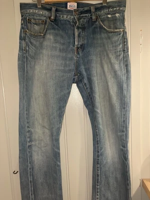 Ljusblå raka jeans från Denim Demon - Snygga ljusblå jeans från Son of a Stag med raka ben och klassisk femficksdesign. Jeansen har slitna detaljer och en vintage tvätt som ger en cool, avslappnad look. Tillverkade i denim med kontrastsömmar och läderpatch bak i midjan.