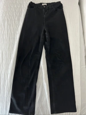 Svarta raka jeans från Lindex - Säljer ett par svarta jeans från Lindex i rak modell. Jeansen har klassisk knapp och dragkedja framtill och är tillverkade i ett mjukt bomullsmaterial. Perfekta till en avslappnad och stilren look.