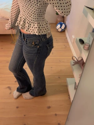 Blå bootcut jeans med fickdetaljer från True religion  - Säljer ett par blå bootcut jeans med snygga fickdetaljer från True Religion som är i st 27. Har aldrig använt därför säljer jag de och för att de är för stora 