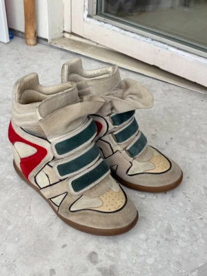 vintage isabel marant kilklack sneakers - färgen har färgats lite på den beigea mockan och en del av skon har klippts av, se bilderna! Annars bra skick. Lite fläckigt inuti men det har jag inte lagt märke till 