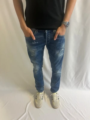 Dondup George | storlek 33  - Tja! Säljer nu dessa blå Dondup George med feta slitningar och paint splatter.                                                                Inga defekter - Storlek 33 - pris 799kr -           Mått: 103 cm längd, 42 cm midja  Hör gärna av er vid intresse eller frågor! 