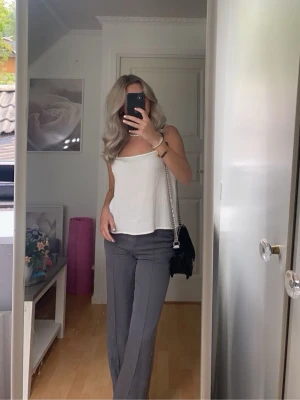 Lila wide kostymbyxor från Madlady - Snygga grå/lila högmidjade kostymbyxor från Madlady i modell med vida ben och pressveck. Byxorna har hällor för bälte och stängs med dragkedja och knapp. 