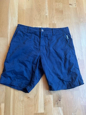 Mörkblå shorts från Junkyard - Snygga mörkblå shorts i chinos material från Junkyard med klassisk passform. Perfekta för varma dagar och enkel att matcha med olika stilar. Dem är endast använda 1 gång!
