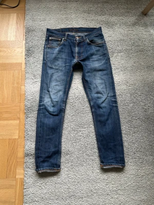 Blå nudie selvedge jeans - Säljer ett par klassiska blå jeans från Nudie selvedge med snygga tvättningar och kontrastsömmar. Modellen har fem fickor, normal passform och raka ben. Perfekta till vardags och funkar till det mesta. Jeansmaterial i bomull. Postas samma dag som köp eller dagen därpå💯🔥. Priset kan diskuteras Storlek 29/30 