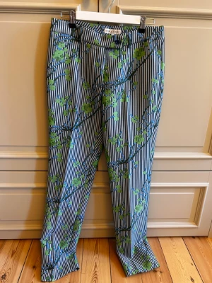 Stunning Anna Holtblad patterned tailored trousers 💚💙 - A really unique pair of statement trousers combining a classic tailored silhouette with a playful, eye-catching print. The blue & white pinstripes are covered with a beautiful green botanical branch pattern, perfect if you want something that stands out while still looking chic and sophisticated.