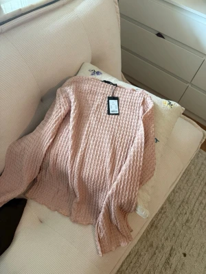 Ljusrosa långärmad topp med struktur - Supersöt ljusrosa topp med lång ärm och vågig struktur i materialet. 