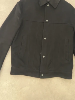 Black Zara Jacket - This is a black jacket from Zara, made in China. It features a button-up front, two side pockets, and a classic collar. The size is Medium (EUR M / USA M / MEX 40).