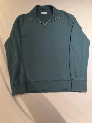Blå halvzip tröja These Glory Days - Snygg blå sweatshirt med halvzip från These Glory Days. Tröjan har hög krage, långa ärmar och breda muddar vid ärmslut och nederkant. Perfekt för en avslappnad och stilren look.